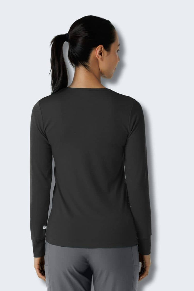 Person wearing a black long-sleeve top and gray pants on a light gray. Wink 2189 Style shirt background