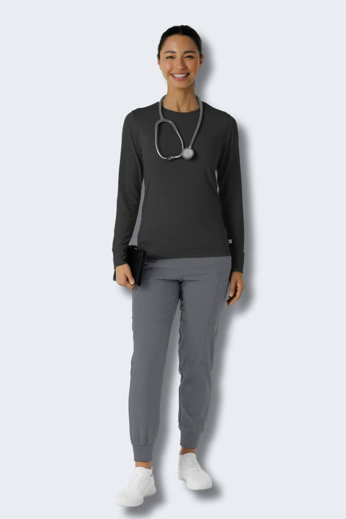 Person wearing a dark long-sleeve top and gray pants on a white background Wink 2189 Style shirt