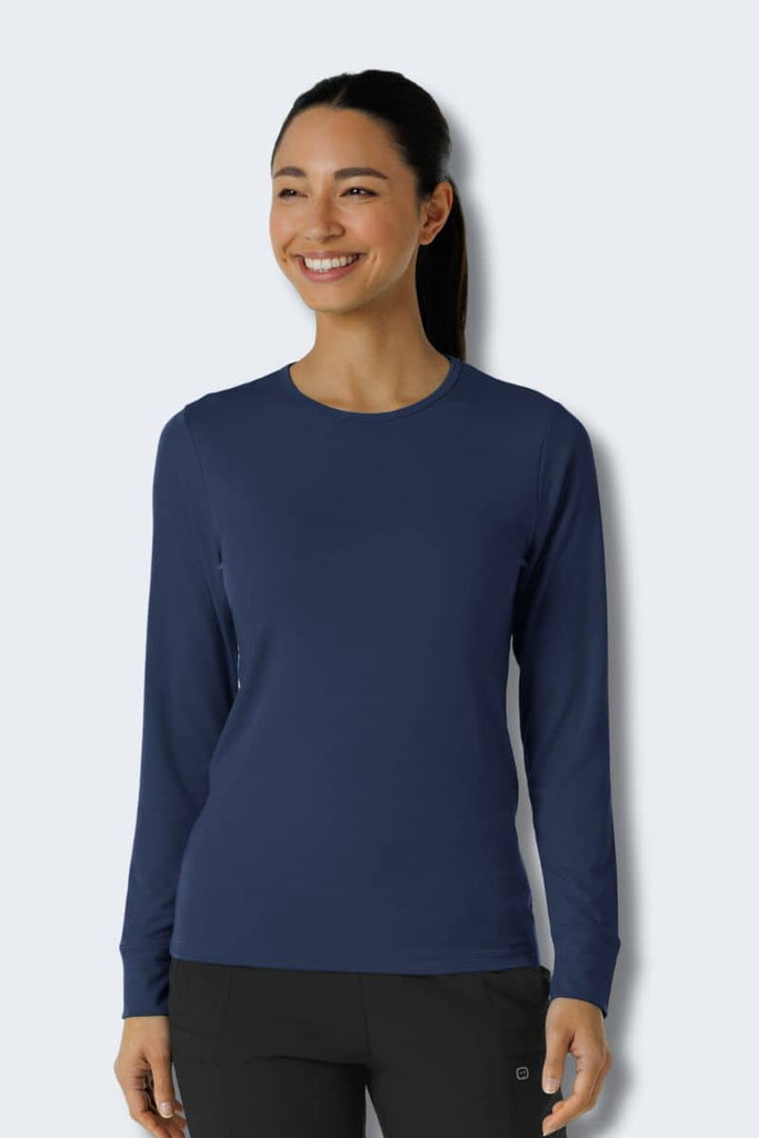 Woman wearing a navy long-sleeve shirt against a white background