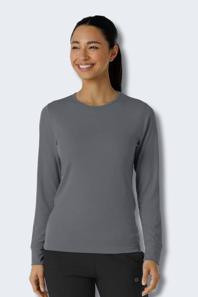 Woman wearing a gray long-sleeve shirt against a white background