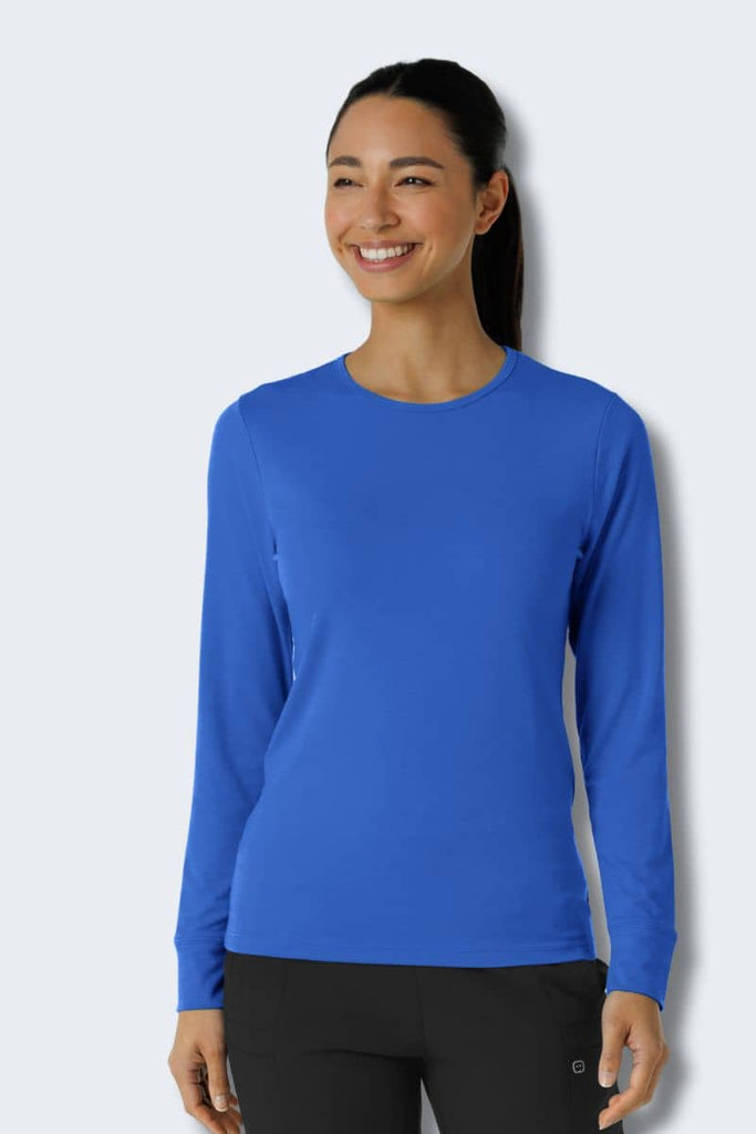 Woman wearing a blue long-sleeve shirt against a light gray background