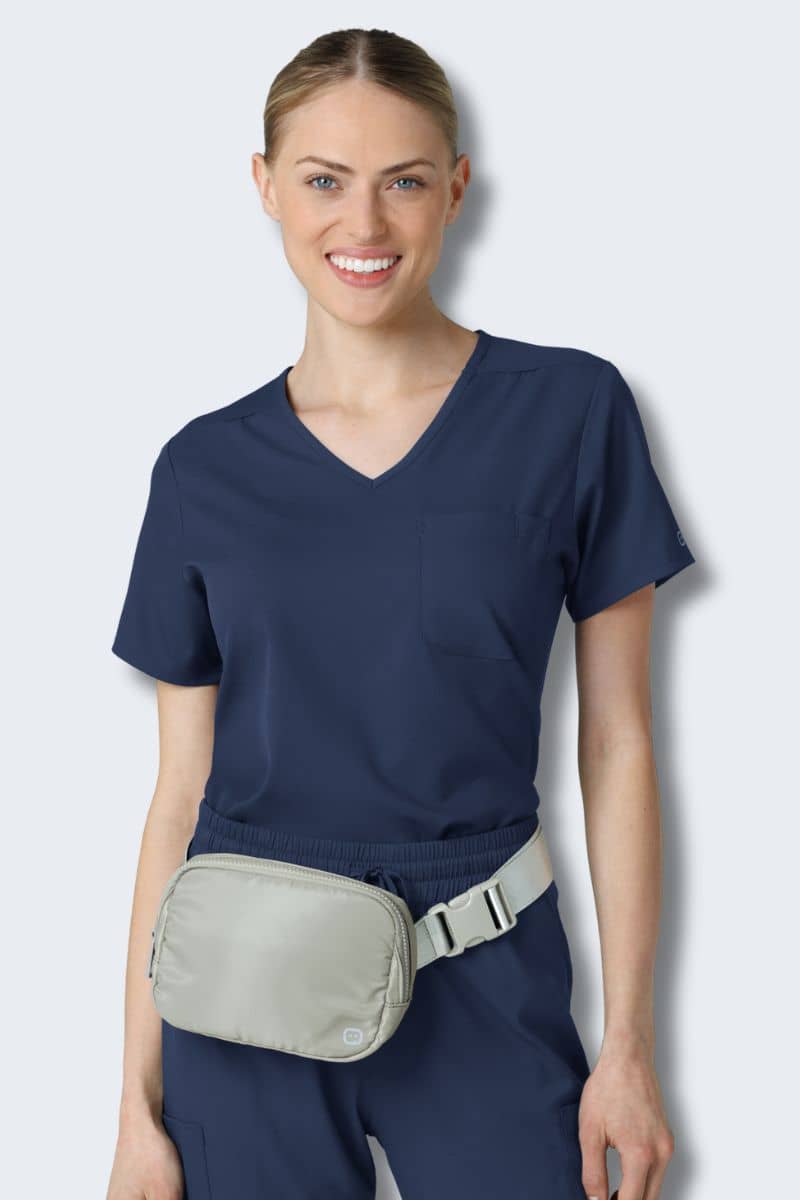 Woman wearing a navy blue scrub set with a beige waist bag on a light gray background. Chatelaine Belt Bag Silver Grey Model 