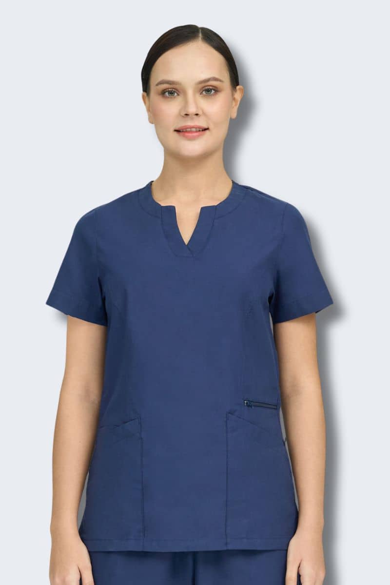 Person wearing a blue scrub set against a light gray background. Amelia
