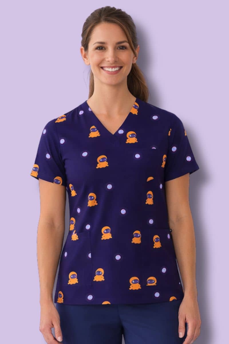Woman wearing a navy blue scrub top with orange patterns on a light purple background. Hospitals United For Sick Kids Unisex Blip Scrubs