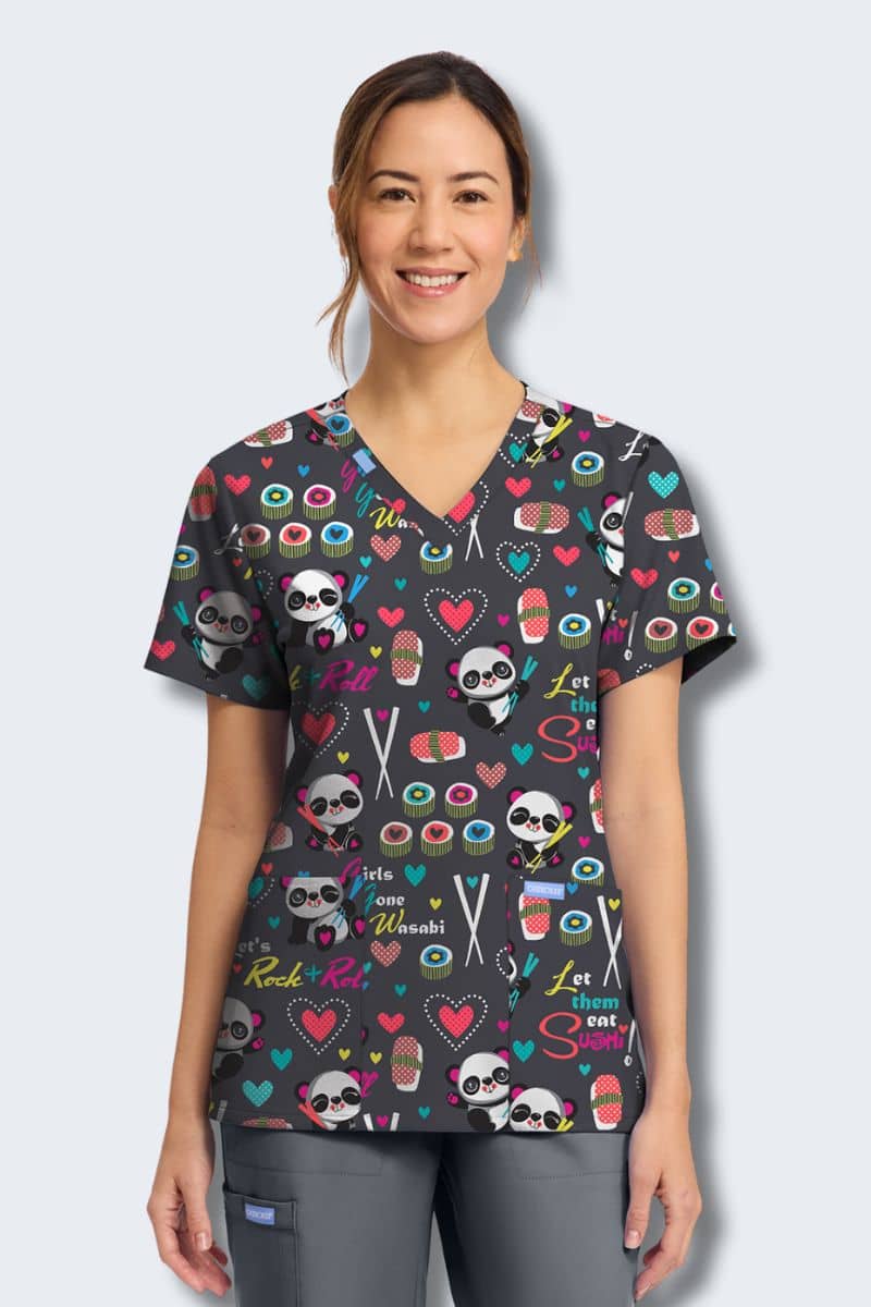 Person wearing a colorful patterned scrub top with cartoon characters on a light gray background