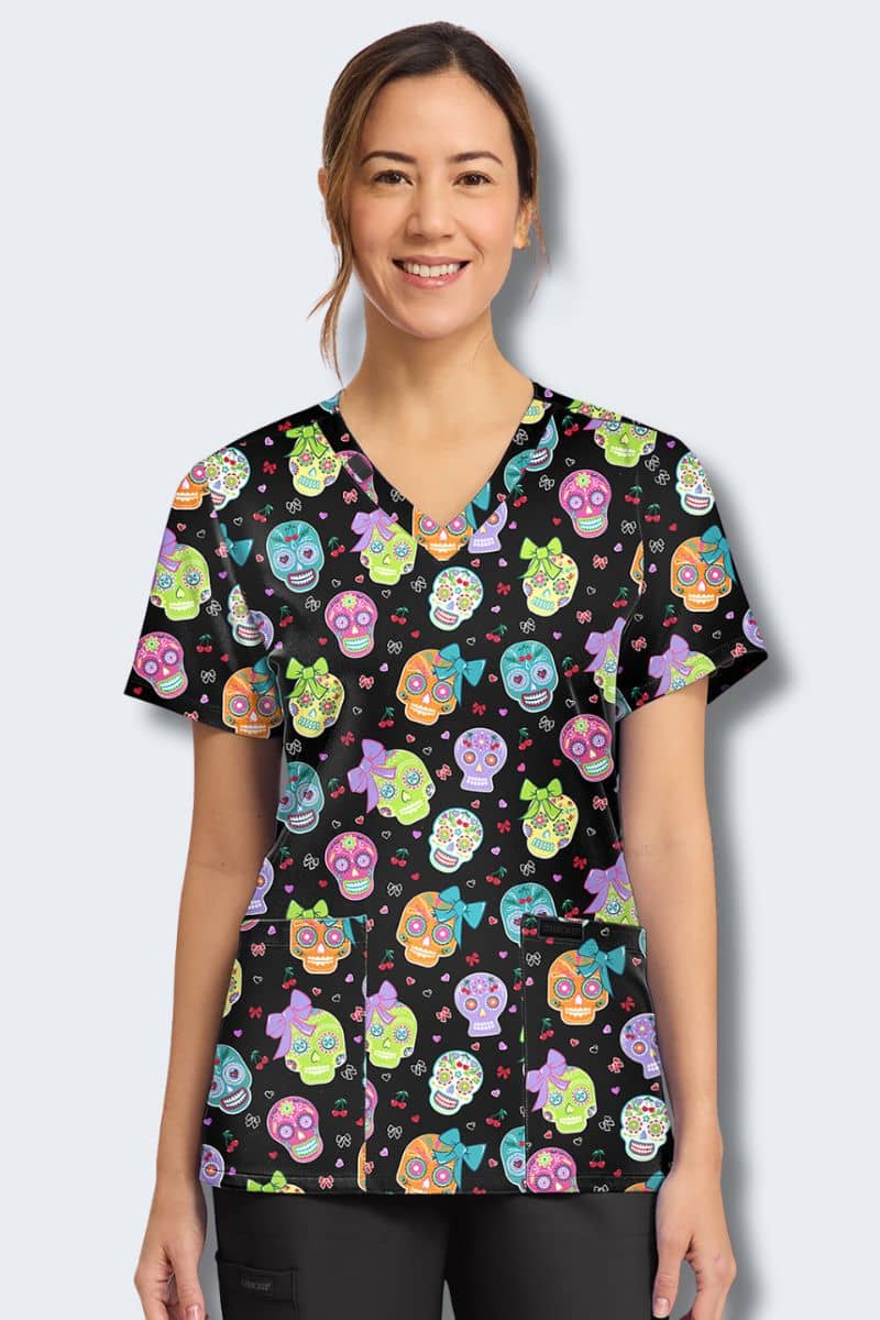 Cherokee CK856 Sweety Skull print scrub top, front view – colourful sugar skulls, bows, hearts and cherries on black, Infectious Clothing Company