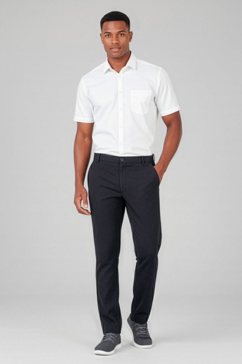 Man wearing a white shirt and black pants on a gray background
