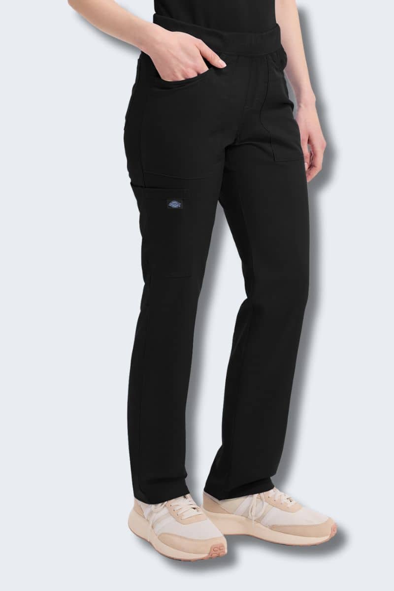 Person wearing black pants with a visible brand logo on a light gray background. Dickies DK135 pant