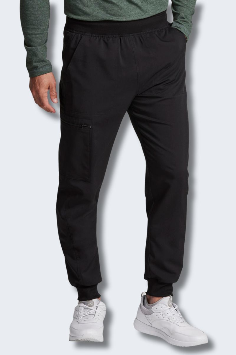 Person wearing black jogger pants and white sneakers on a light gray. background. Dickies DK224 front view