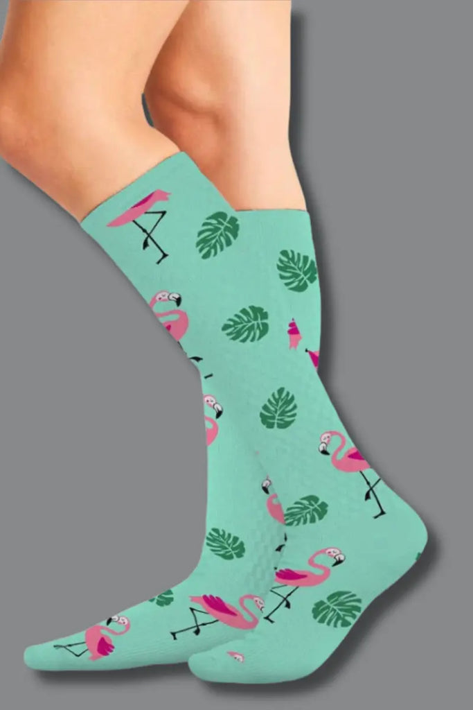 Teal sock with flamingo and leaf pattern on a gray background