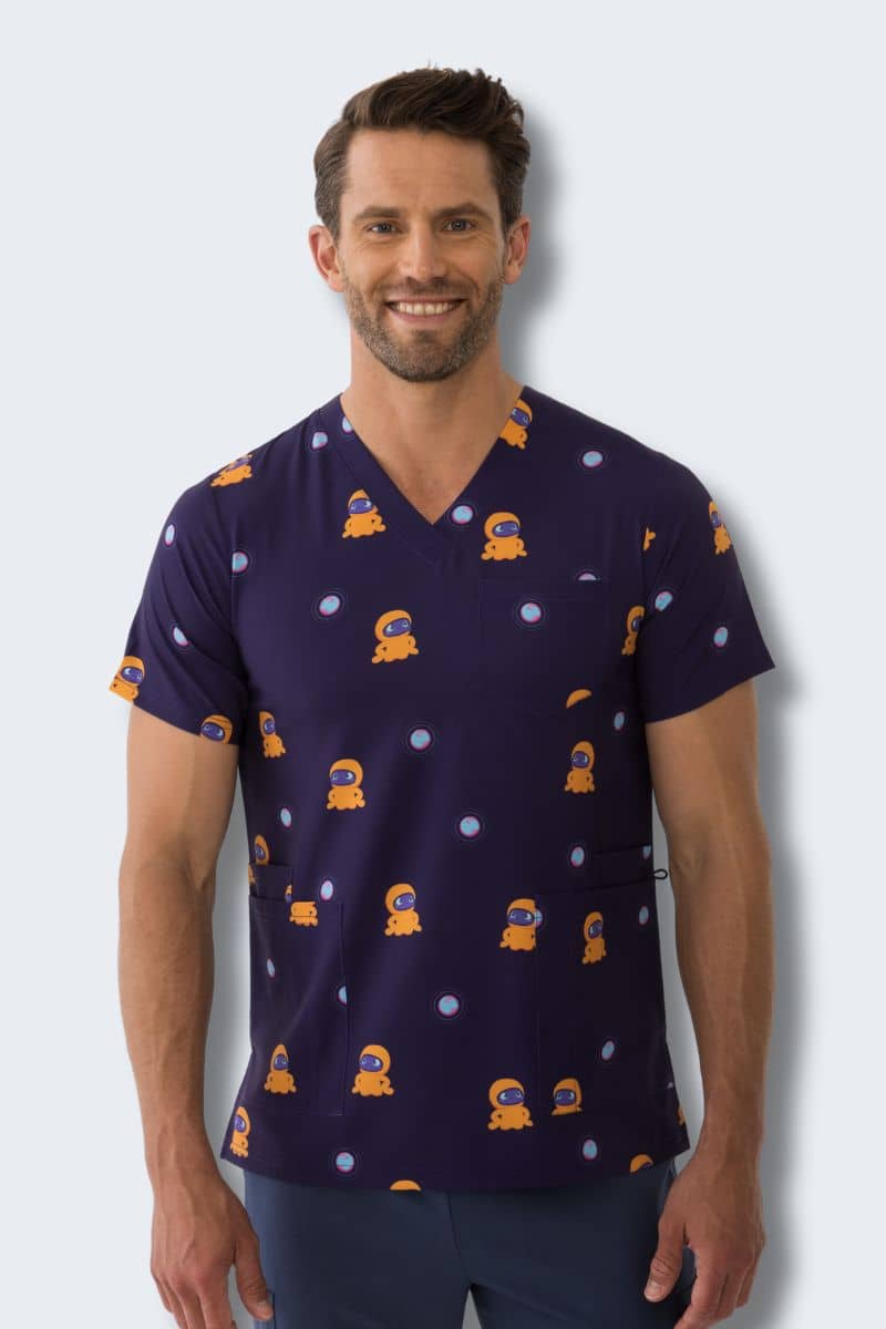 Man wearing a navy blue scrub top with orange and white pattern against a light gray background. Hospitals for Sick Kids Blip Print Scrubs infectious.com.au