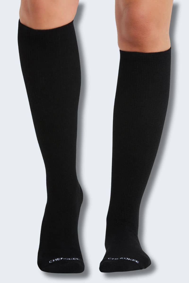 Black knee-high socks on a person's legs against a white background. Bamboo compression socks