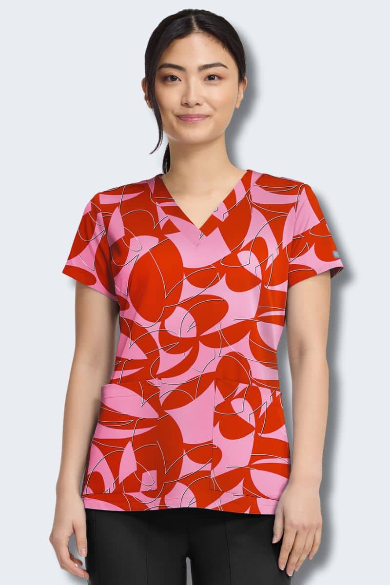 Woman wearing a red and pink patterned blouse on a light gray background