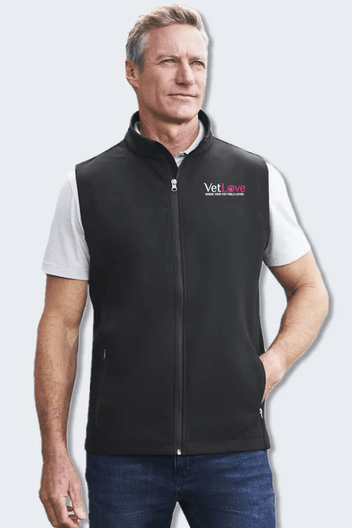 Man wearing a black vest with a logo on a light gray background. Vetlove