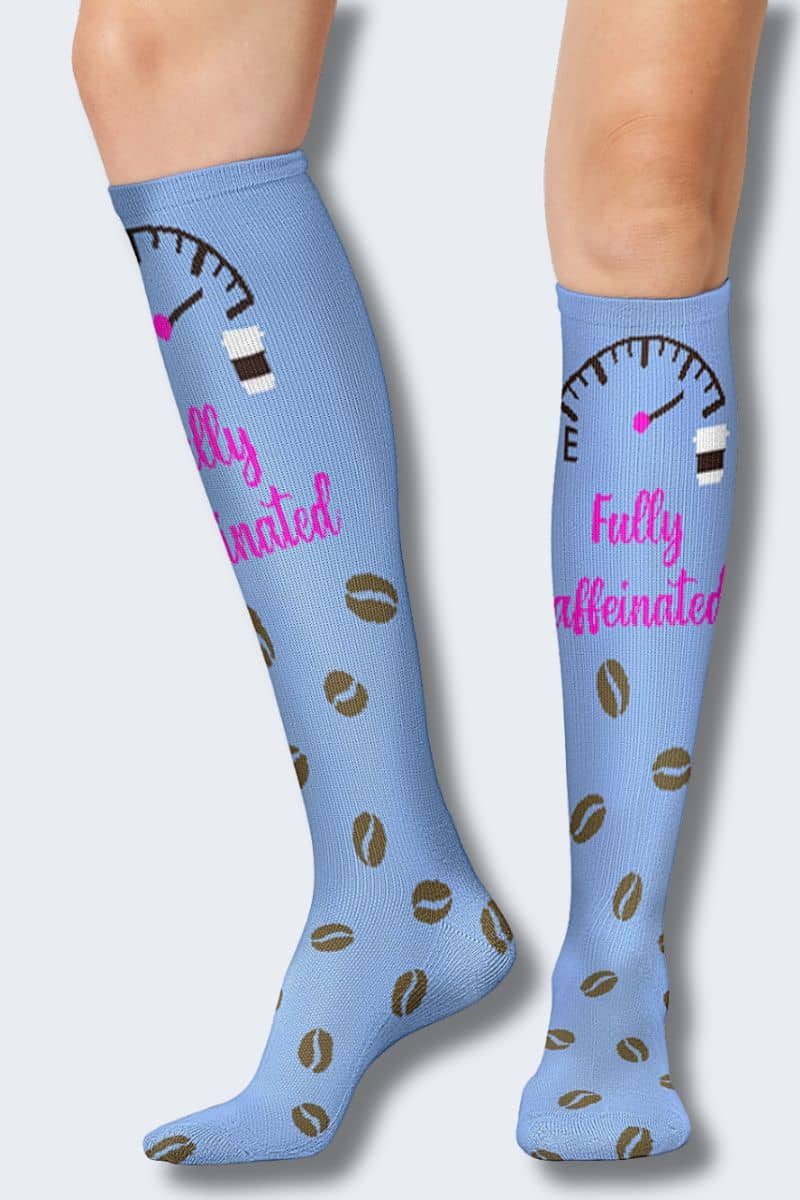 Blue knee-high socks with coffee bean pattern and 'Fully caffeinated' text on a light gray background