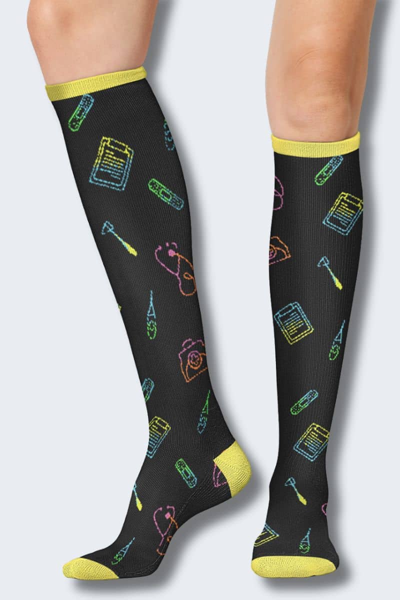 Black knee-high socks with colorful patterns and yellow accents worn by a person on a light gray background