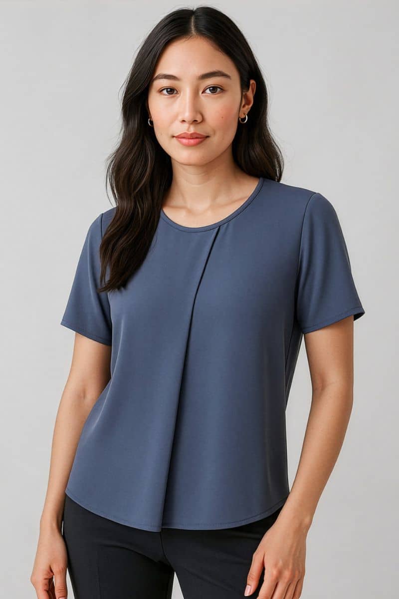 Woman wearing a blue short-sleeve top against a gray background